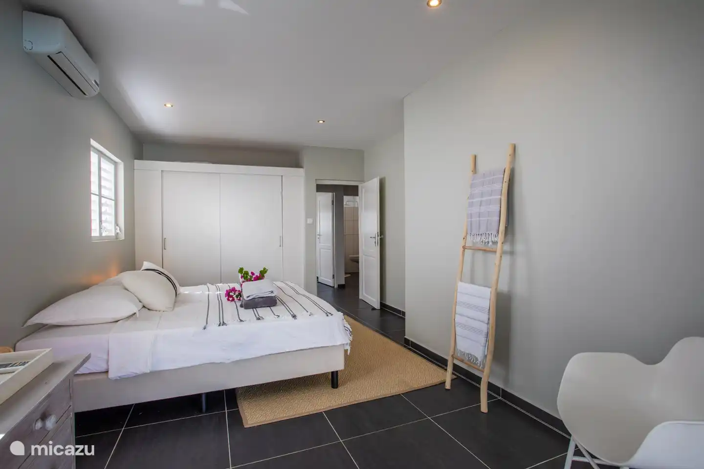 Dormitorio con puertas de patio a terraza y piscina.