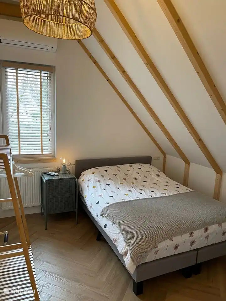 Schlafzimmer 4 mit Boxspring, TV und offenem Kleiderständer.