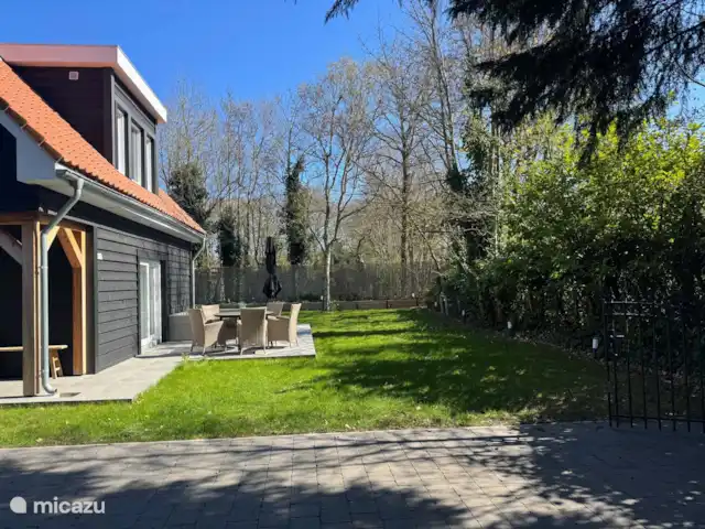Villa Rein | Pays-Bas, Zélande, Renesse - maison de vacances Jardin spacieux avec terrasse ensoleillée et beaucoup d’intimité, parfait pour le petit-déjeuner au soleil ou une soirée agréable à l’extérieur. Entouré de verdure et de tranquillité, avec allée privée et portail pour plus de confort.