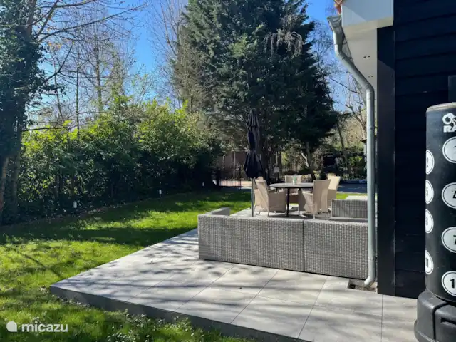 Villa Rein | Pays-Bas, Zélande, Renesse - maison de vacances Terrasse ensoleillée avec coin salon et table à manger, idéale pour se détendre ou dîner à l’extérieur. Entouré de verdure et d’arbres ombragés pour un séjour merveilleusement privé et reposant.
