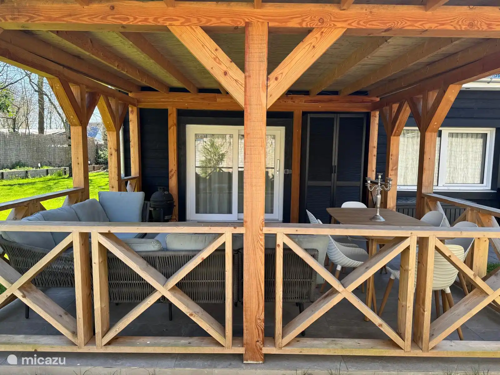 Attraktive Veranda mit bequemen Stühlen und Esstisch, ideal für lange Abende im Freien. Geschützt, gemütlich und mitten im Grünen – hier können Sie jeden Moment des Tages genießen!