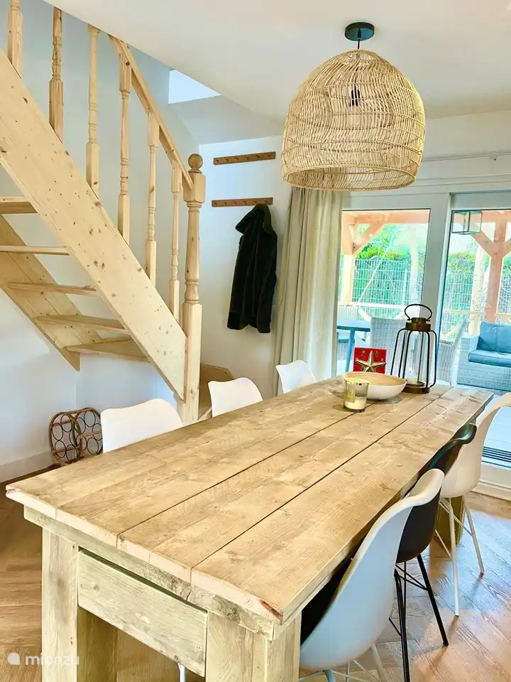 Gemütlicher Essbereich mit handgefertigter Holztreppe, angrenzend an die überdachte Terrasse.