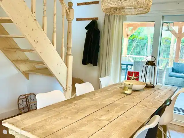 Villa Rein | Pays-Bas, Zélande, Renesse - maison de vacances Salle à manger confortable avec escalier en bois fait à la main, adjacente à la terrasse couverte.