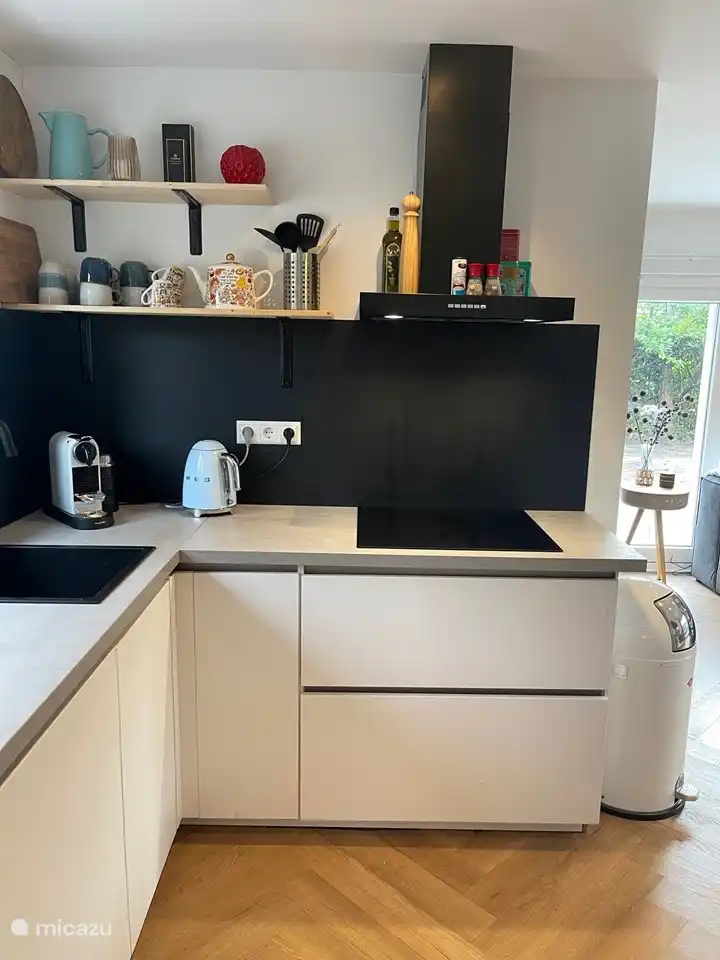 Luxuriöse offene Küche mit Einbaugeräten; Geschirrspüler, Induktionskochfeld, Kombibackofen und Mikrowelle, Einbaukühlschrank, Smeg-Kühlschrank mit Gefrierfach, Wasch- und Trockenmaschine in 1, Smeg-Wasserkocher und Nespresso-Kaffeemaschine und Sandwichmaker vorhanden.