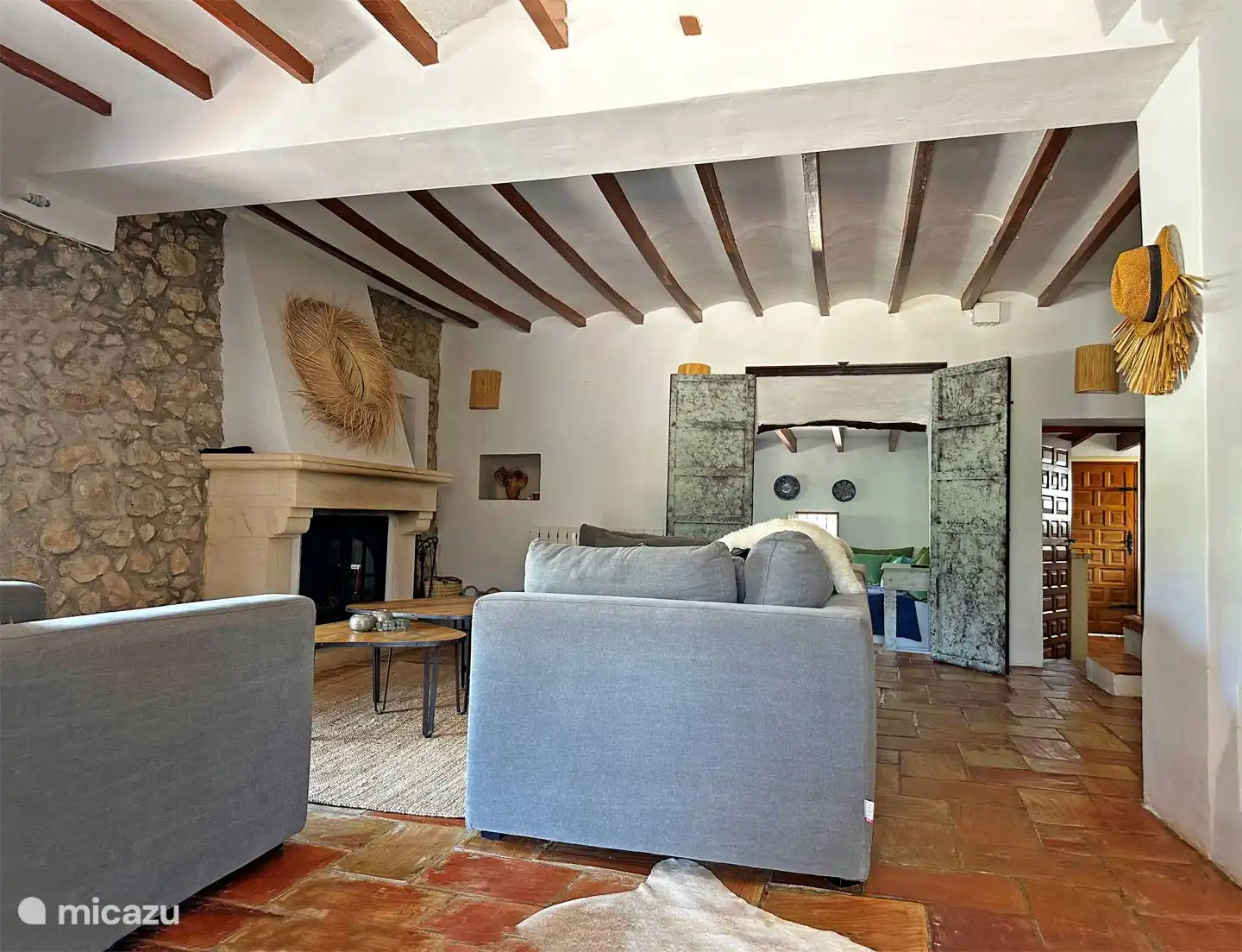 Das Wohnzimmer mit Holzofen und Durchgang zum Fernsehraum und rechts der Durchgang zur Küche