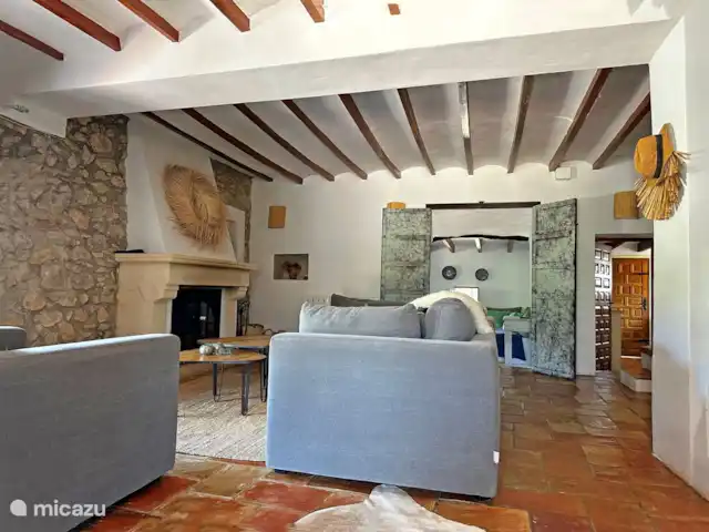 Casa Grilló en España, Costa Blanca, Lliber - finca La sala de estar con estufa de leña y paso a la sala de televisión y a la derecha el pasaje a la cocina
