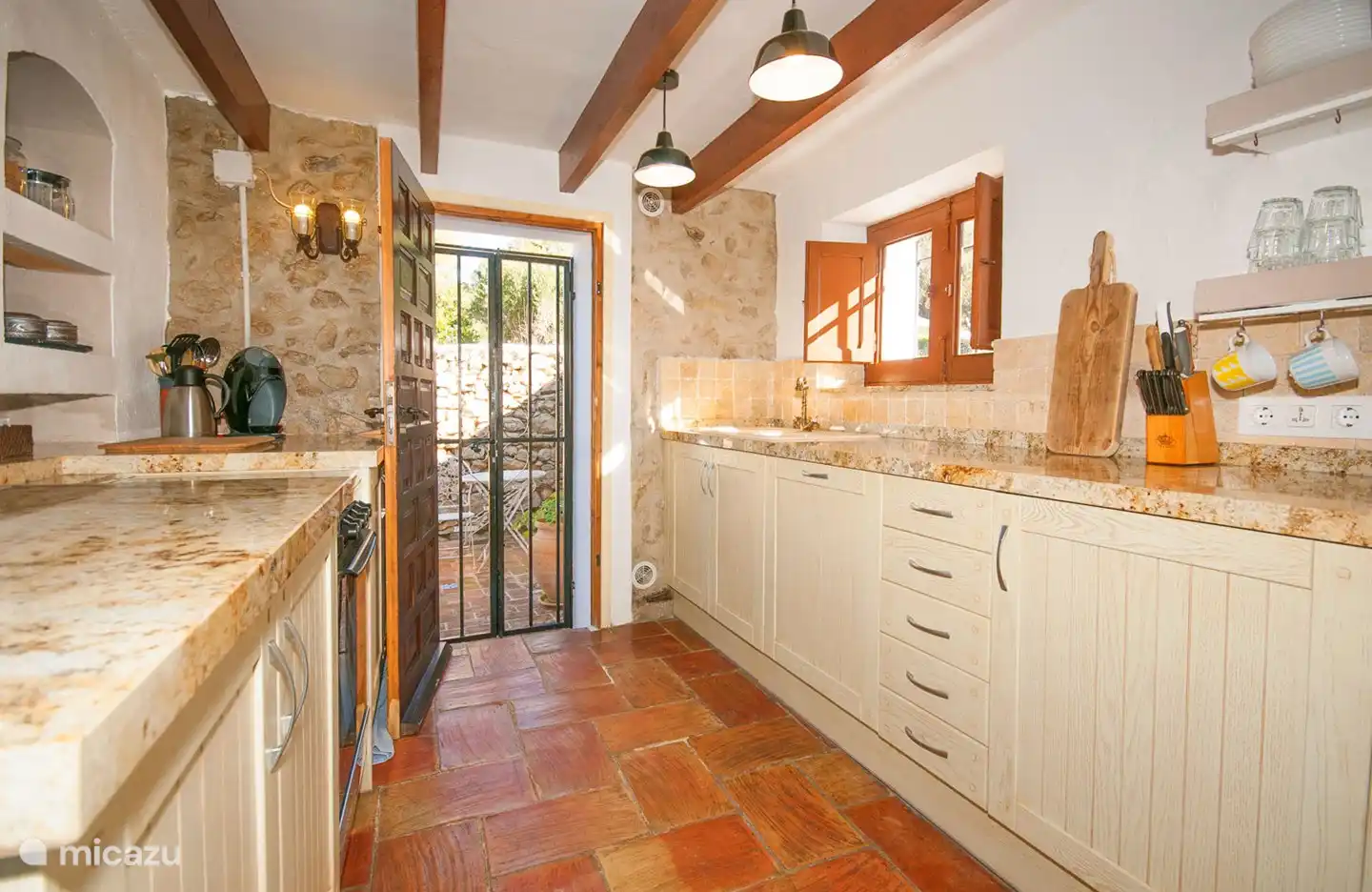 Übersichtsfoto der kompletten Küche mit der Hintertür, die Zugang zur kleinen privaten Terrasse bietet