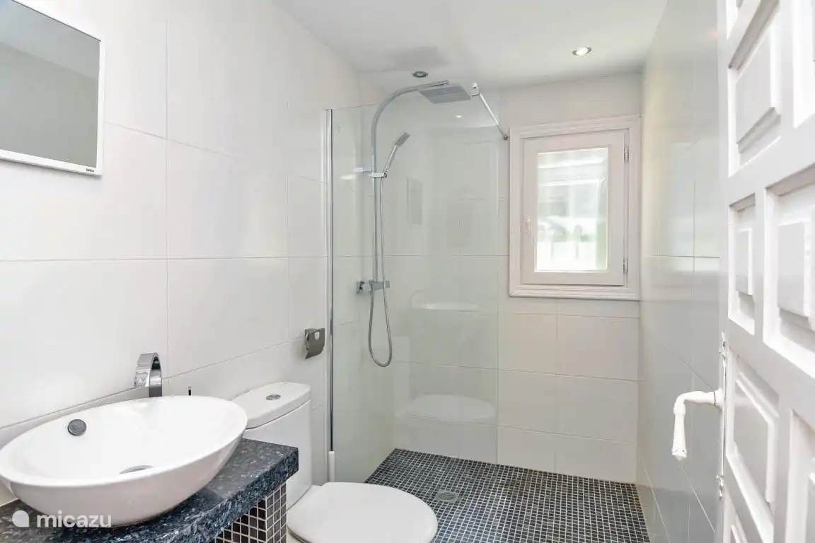 Badezimmer im ersten Stock, mit Heizung, Toilette, Waschbecken und Dusche.