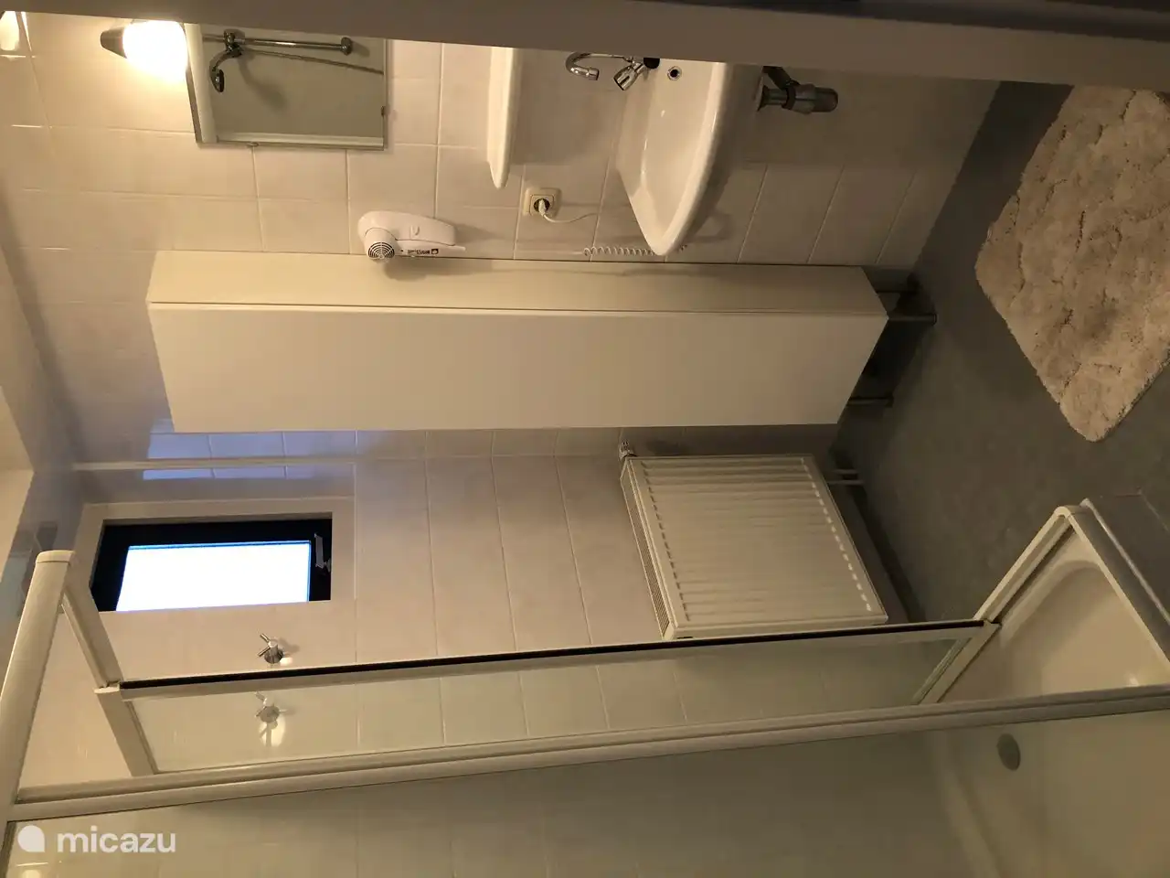 Badezimmer mit Waschbecken und Duschkabine