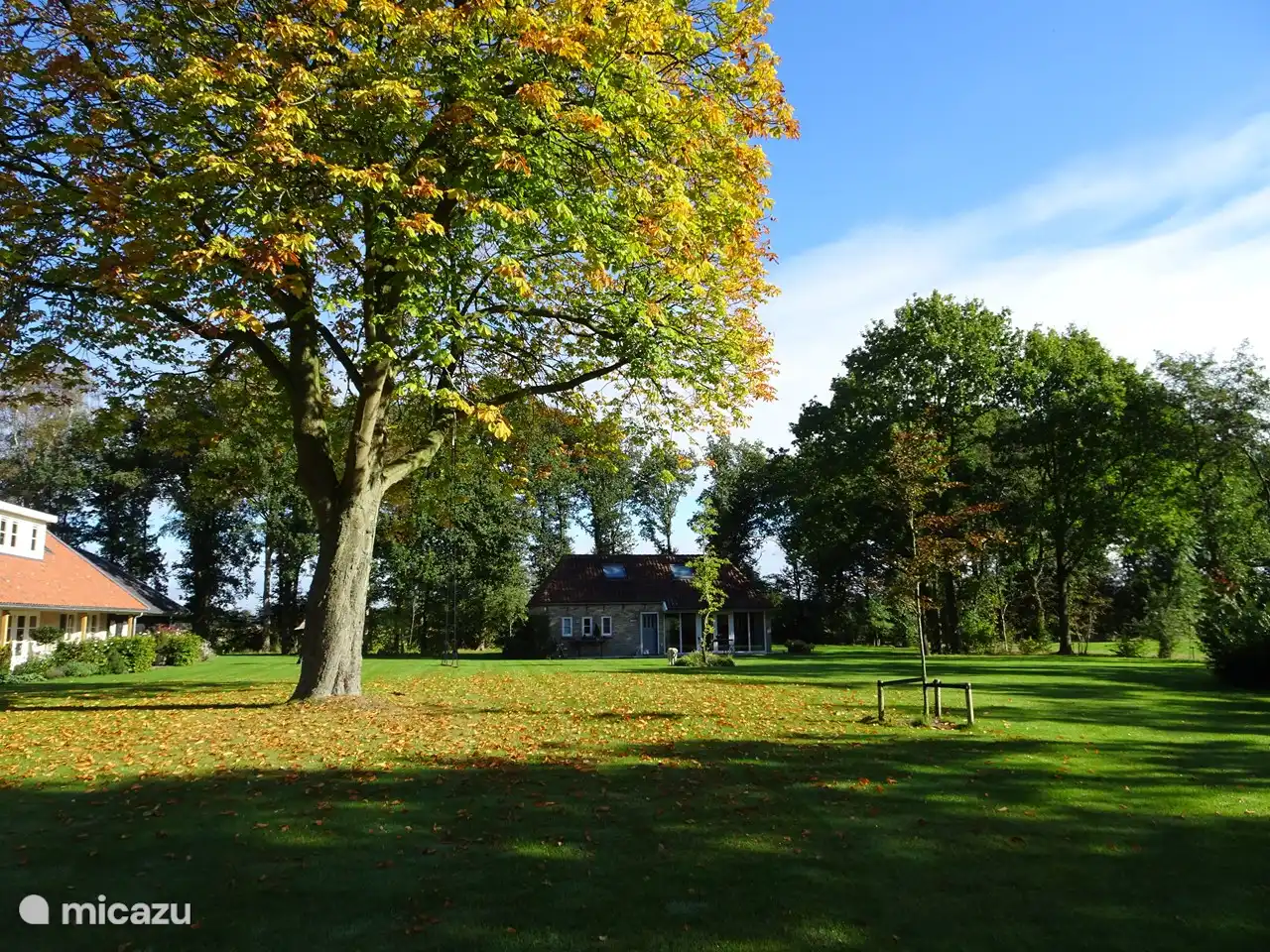 Vue d'ensemble du jardin avec la maison en arrière-plan. Sur la partie gauche de la maison principale. Distance suffisante, l'intimité est garantie.