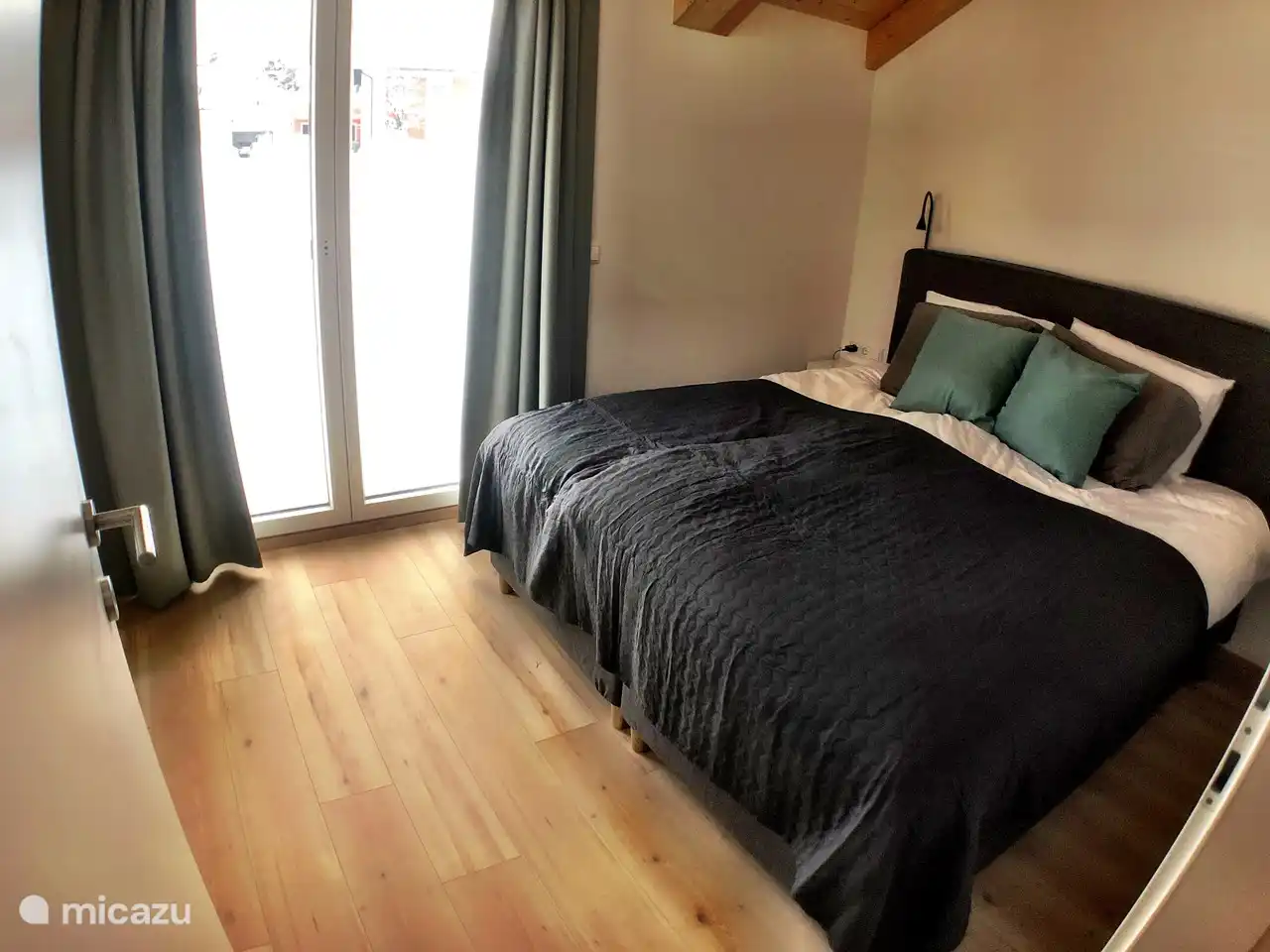 Chambre à l'arrière avec porte patio donnant sur le balcon. Tous les lits ont deux oreillers et des draps en coton égyptien.