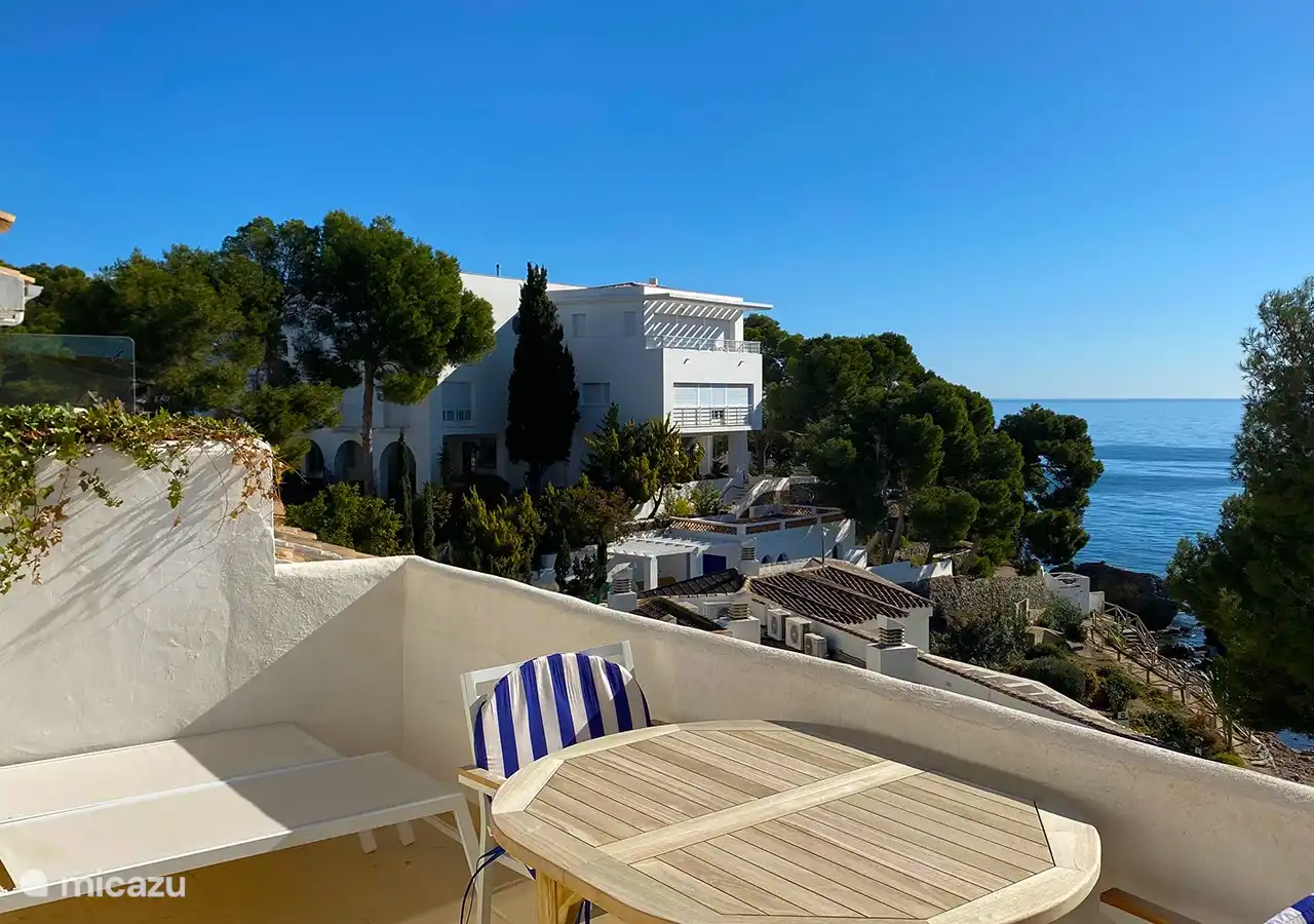 terraza con tumbonas y mesa de comedor