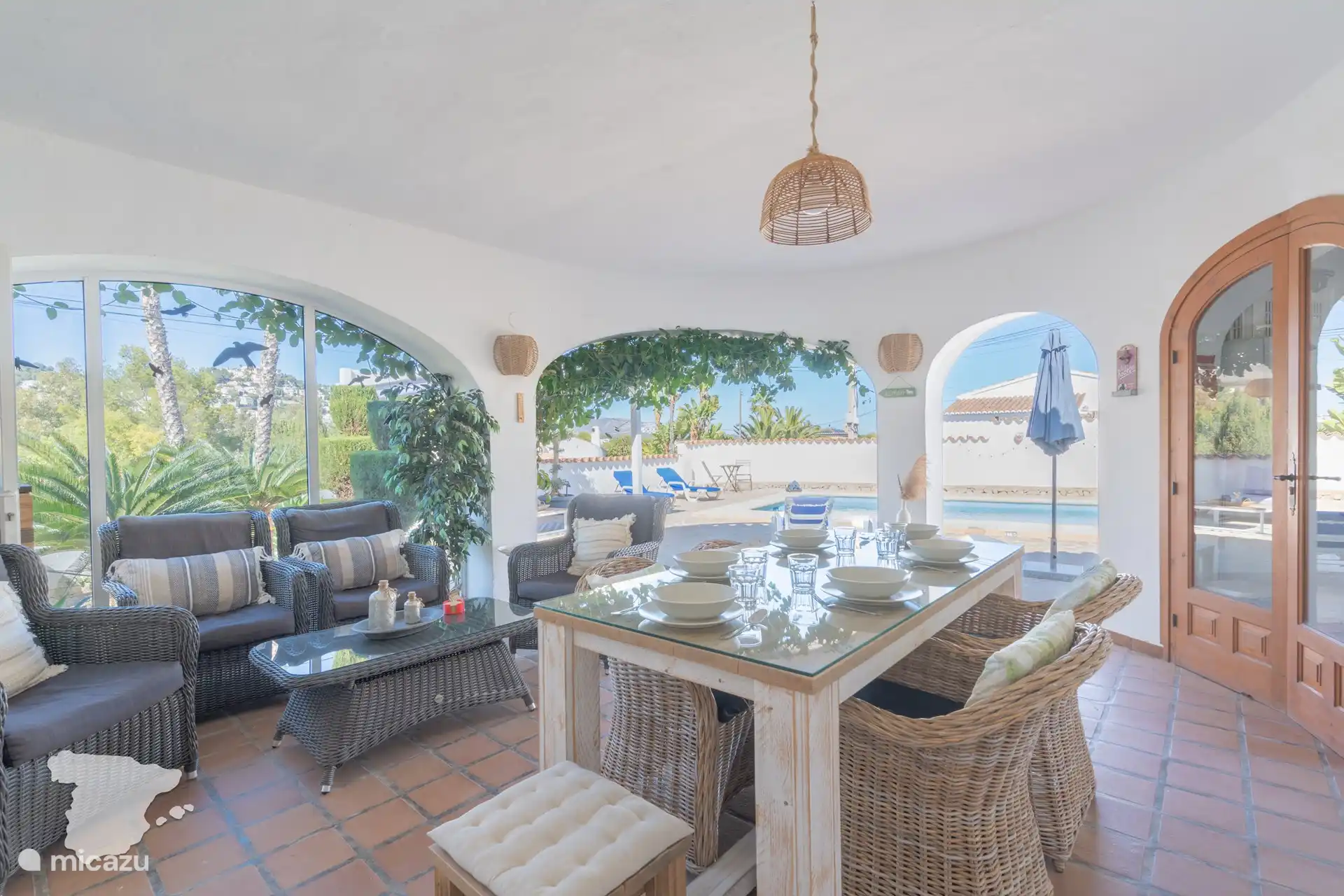 Covered terrace with dining table and cozy seating areas