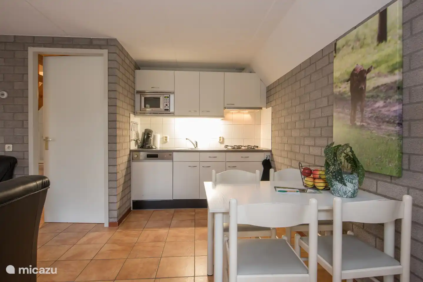 Der Esstisch und die voll ausgestattete Küche