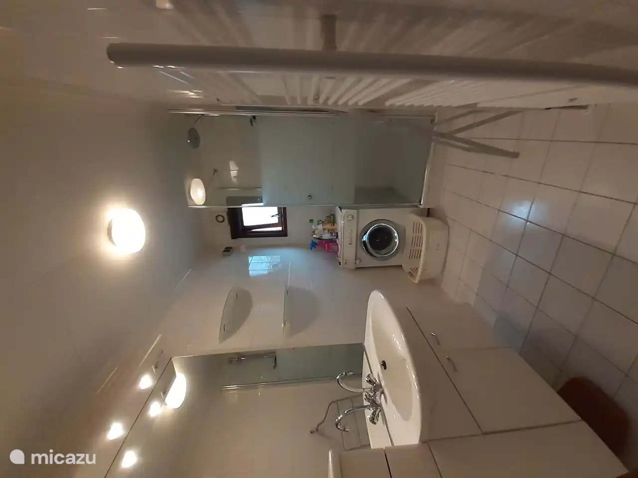 The bathroom with shower furniture, shower, washing machine and dryer.