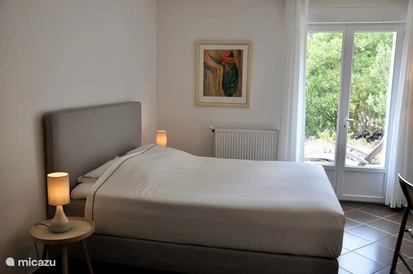 Geräumiges Schlafzimmer (1) auf der Wohnetage, mit komfortablem Boxspringbett. Direkter Zugang zum Badezimmer. Terrassentüren zur Terrasse.