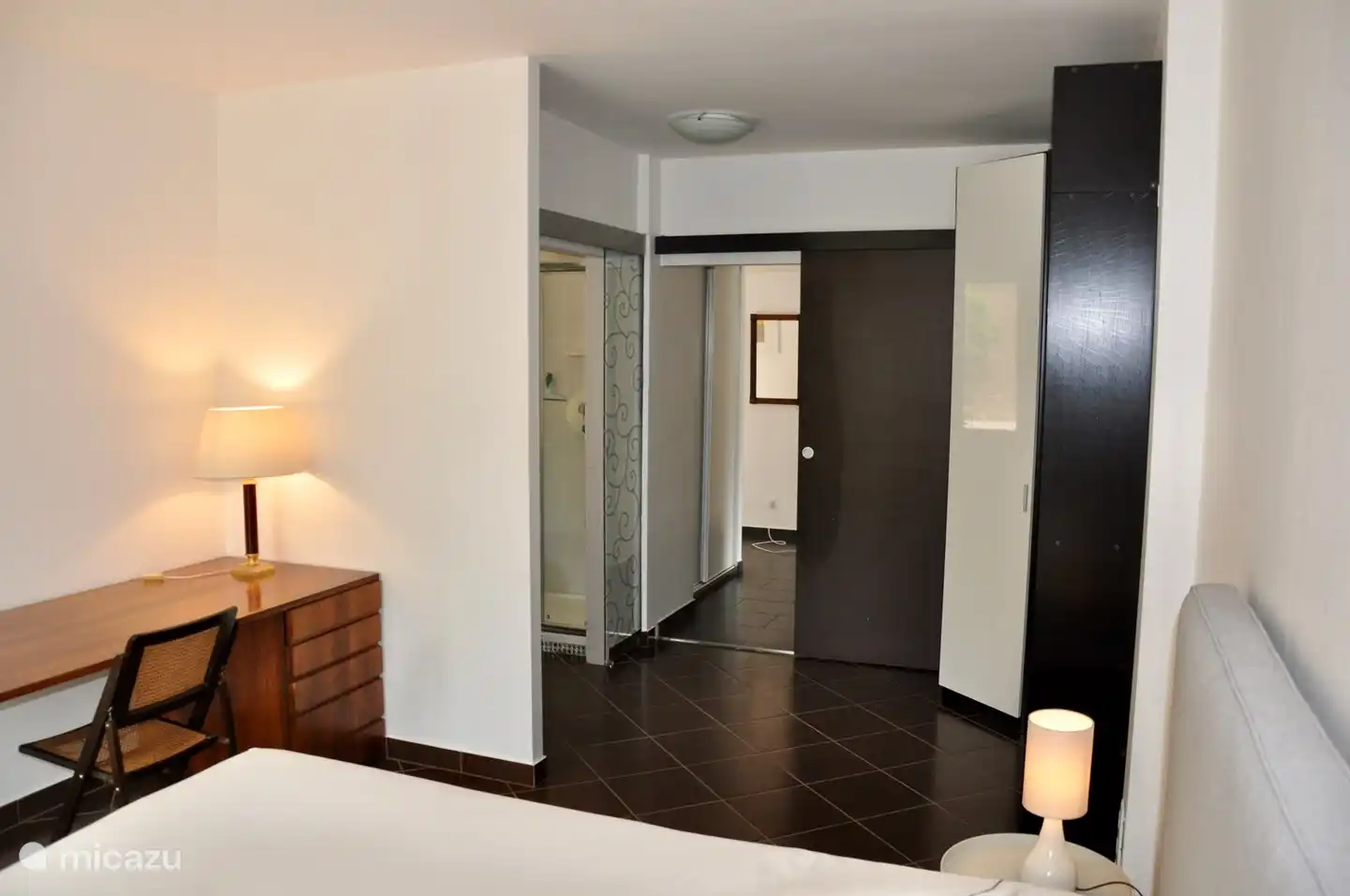 Geräumiges Schlafzimmer (1) auf der Wohnetage, mit komfortablem Boxspringbett. Direkter Zugang zum Badezimmer. Terrassentüren zur Terrasse.