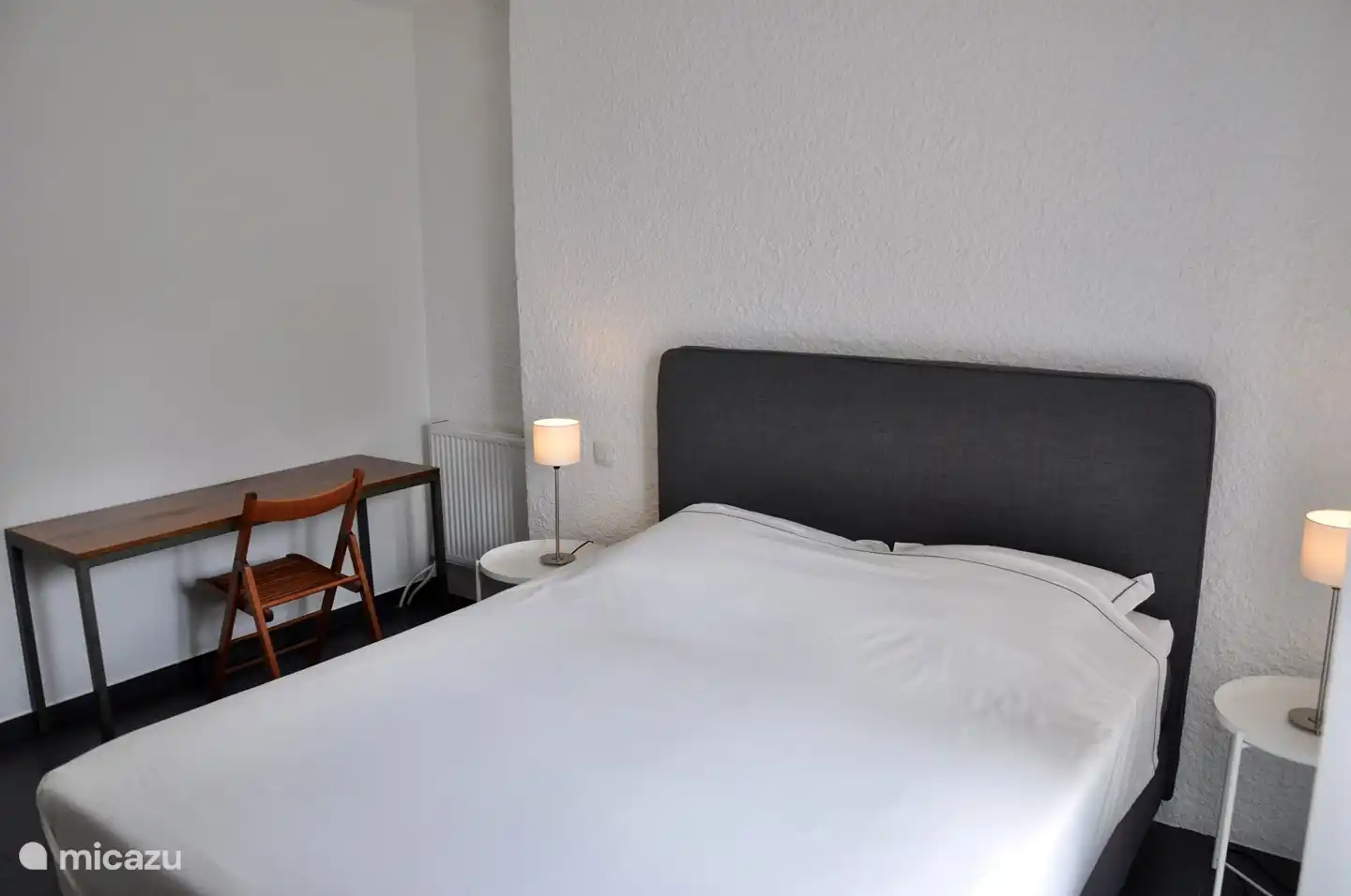 Geräumiges Schlafzimmer (2) auf der Wohnetage, mit komfortablem Boxspringbett, eigenem Waschbecken und Terrassentüren nach außen.