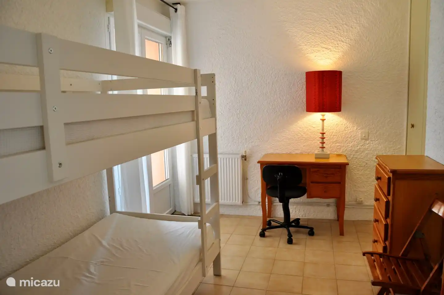 Kleines Schlafzimmer (4) im Erdgeschoss, mit Etagenbett, mit Terrassentüren zur Terrasse und direktem Zugang zum Pool.