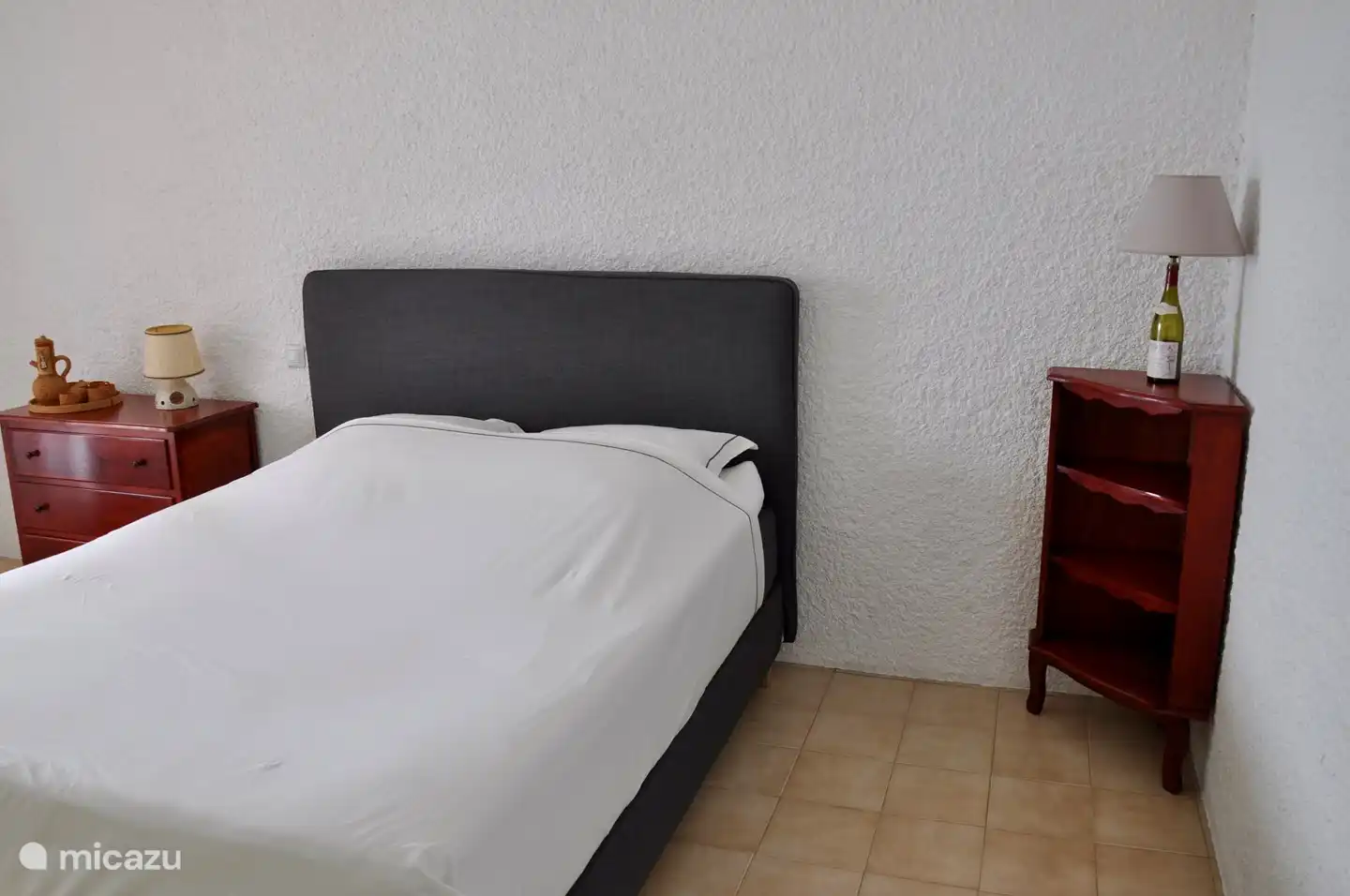 Geräumiges Schlafzimmer (5) im Erdgeschoss, ausgestattet mit einem komfortablen Boxspringbett, mit Terrassentüren zur Terrasse und direktem Zugang zum Swimmingpool.