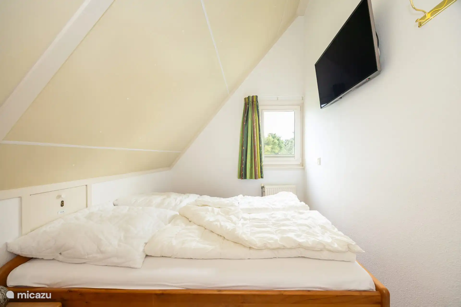 Das zweite Schlafzimmer mit dem 43-Zoll-Fernseher an der Wand