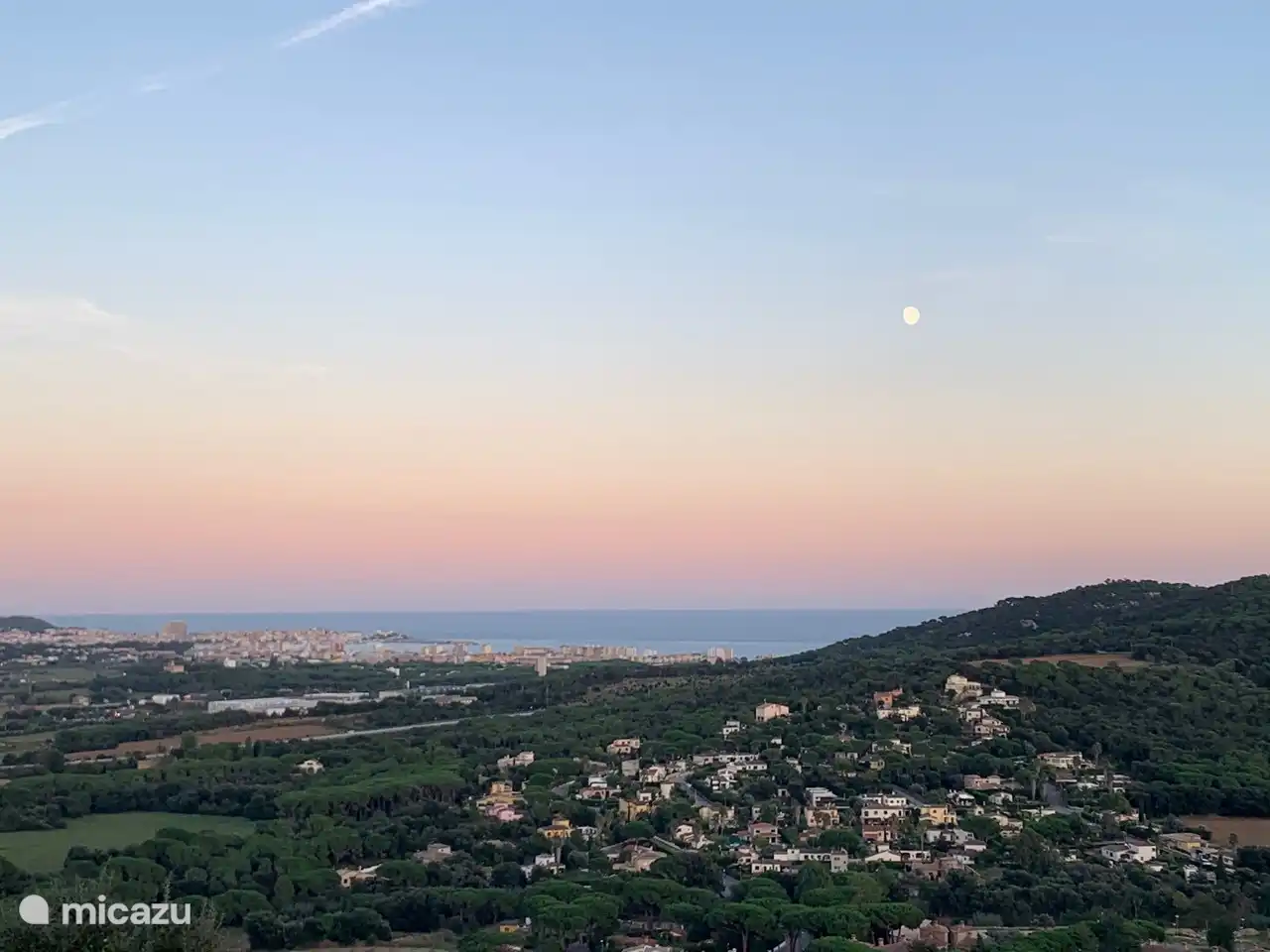 The moon rises over the sea.