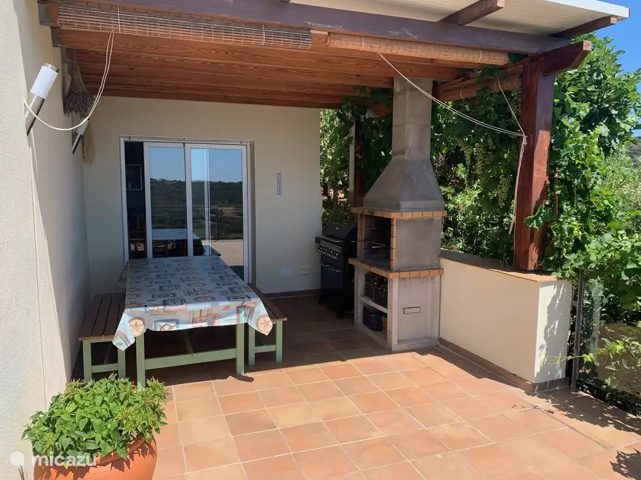 Dining table and BBQs. Dining table can be extended. There are 2 extra benches for the table: a total of 4. Sliding door is the entrance to the kitchen.