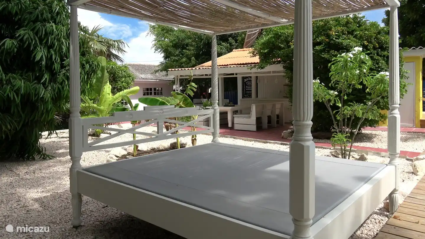 Lit à baldaquin décontracté au bord de la piscine.