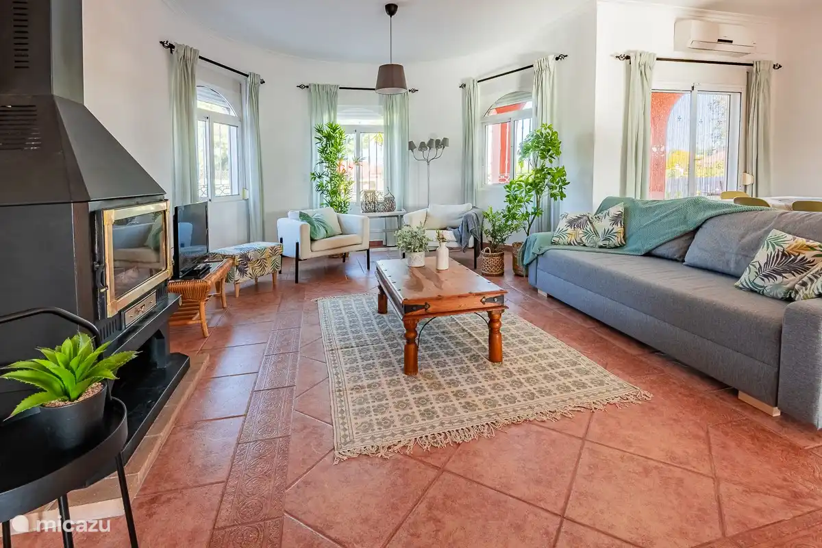 beau salon spacieux avec climatisation, cheminée, beaucoup de lumière, et TV écran plat, WiFi