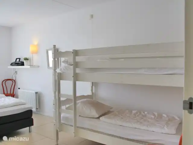 vida en la playa 1 en Países Bajos, Holanda del Norte, Callantsoog - casa vacacional dormitorio con una cama doble y una litera