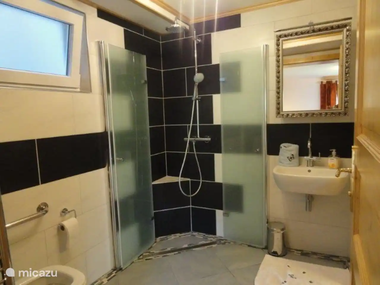 Badezimmer mit Dusche, Waschbecken und Toilette