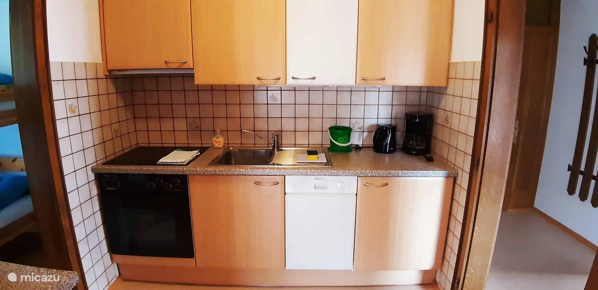 Keuken vakantiewoning Anemoon met koelkast met vriesvak, afwasmachine, keramische kookplaat met oven en alles wat nodig is om een lekkere maaltijd te koken.