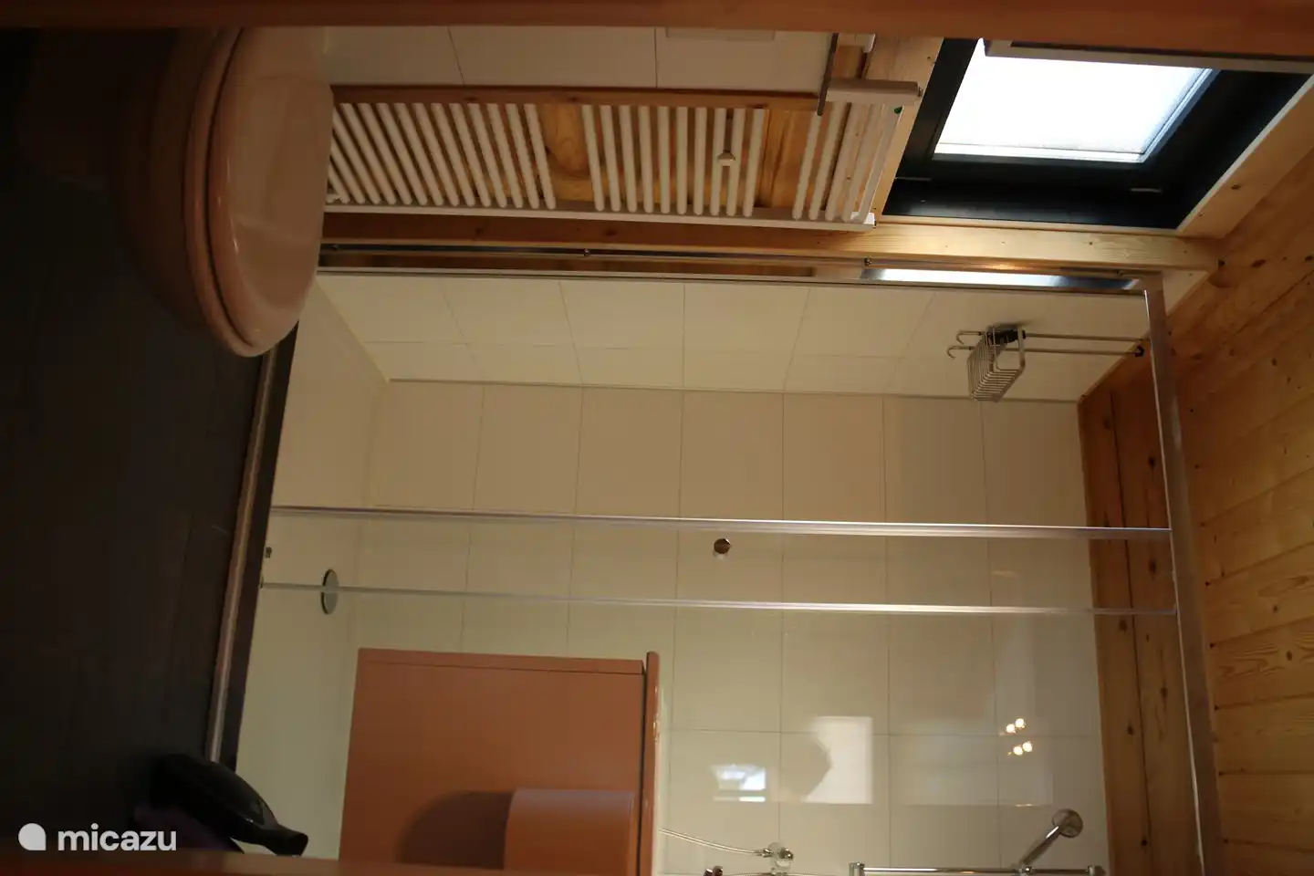 Badezimmer mit Dusche, Waschbecken und Toilette.