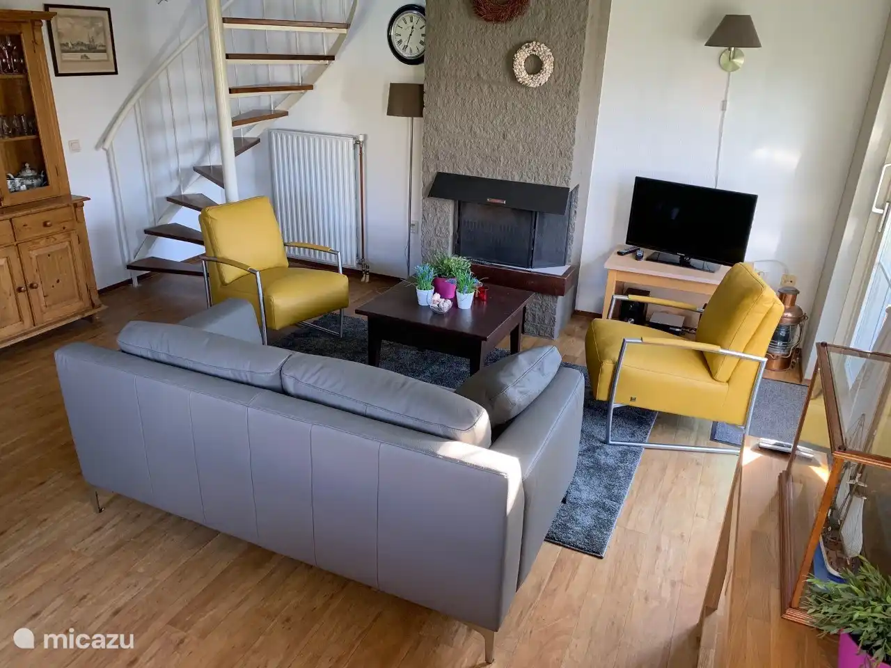 Coin salon avec de nouveaux meubles en cuir, une cheminée et des portes coulissantes donnant sur la terrasse à l'avant de la maison