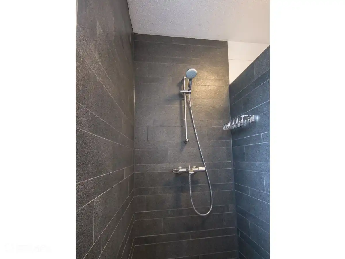 Salle de bain rénovée avec douche à l'italienne avec un lavabo séparé et un radiateur design