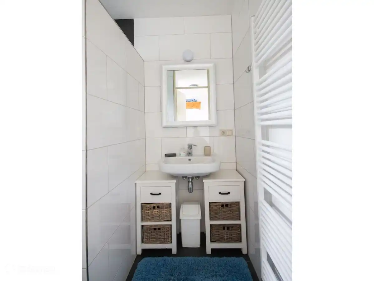 Salle de bain rénovée avec douche à l'italienne avec un lavabo séparé et un radiateur design