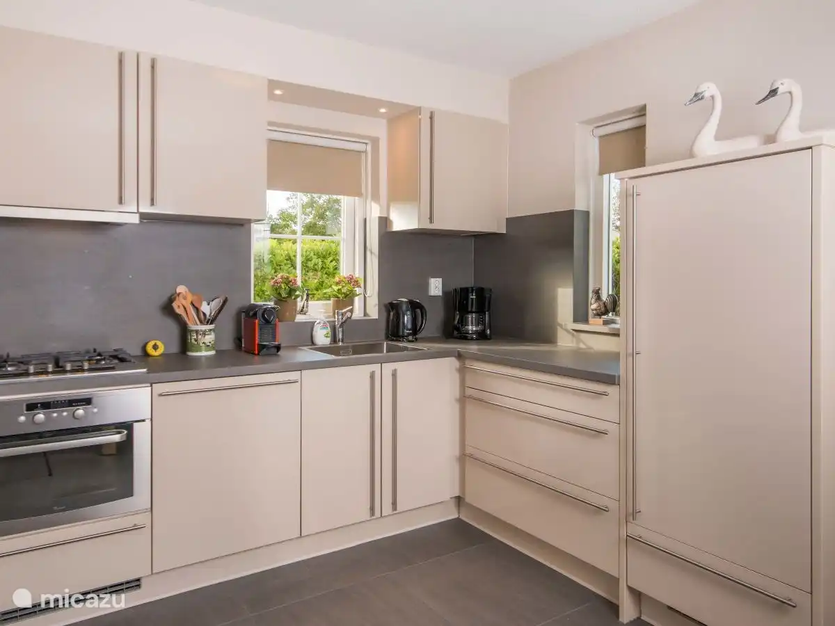 Moderne open keuken voorzien van vaatwasser, koelkast met vriesvak, combi oven en diverse koffiezetapparaten