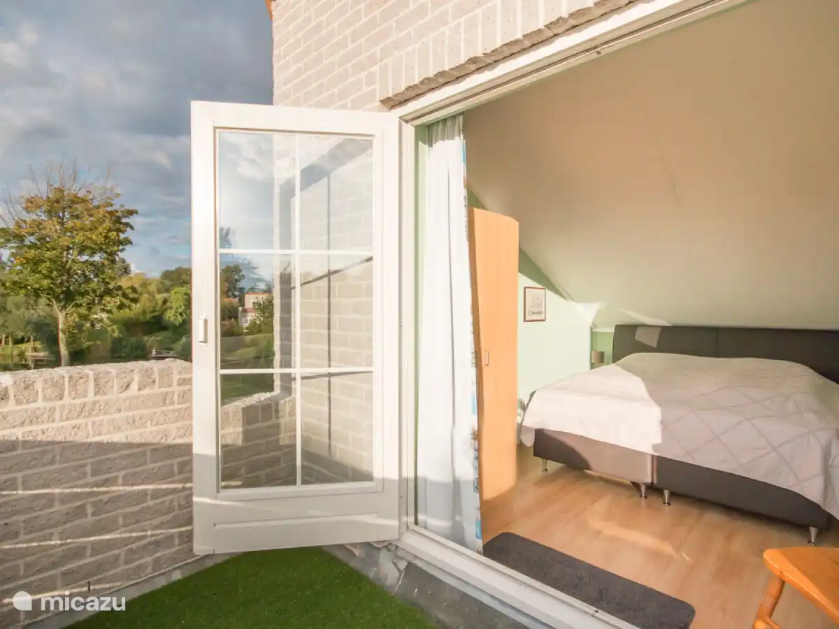 Hoofd slaapkamer met groot balkon met uitzicht op de mooie zonnige tuin