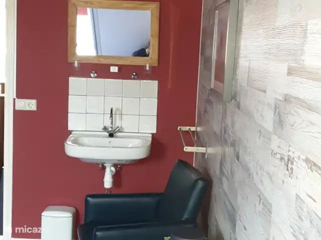 El Smousenhoek en Países Bajos, Holanda Meridional, Ouddorp - casa vacacional Dormitorio de playa con TV, lavabo, llave privada y armario.