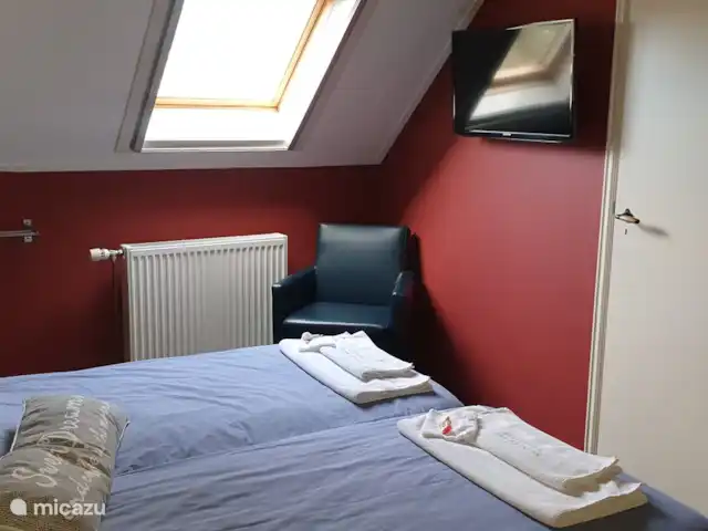 El Smousenhoek en Países Bajos, Holanda Meridional, Ouddorp - casa vacacional Dormitorio de playa con TV, lavabo, llave privada y armario.