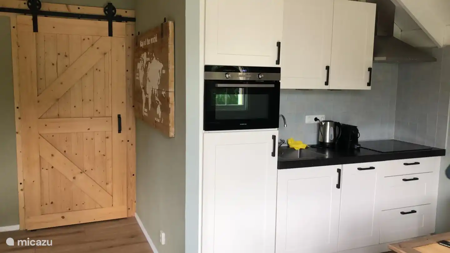 Küche mit Geschirrspüler, Kombi-Mikrowelle und Induktionskochfeld. Nespresso- und Kaffeemaschine (Filter) vorhanden.