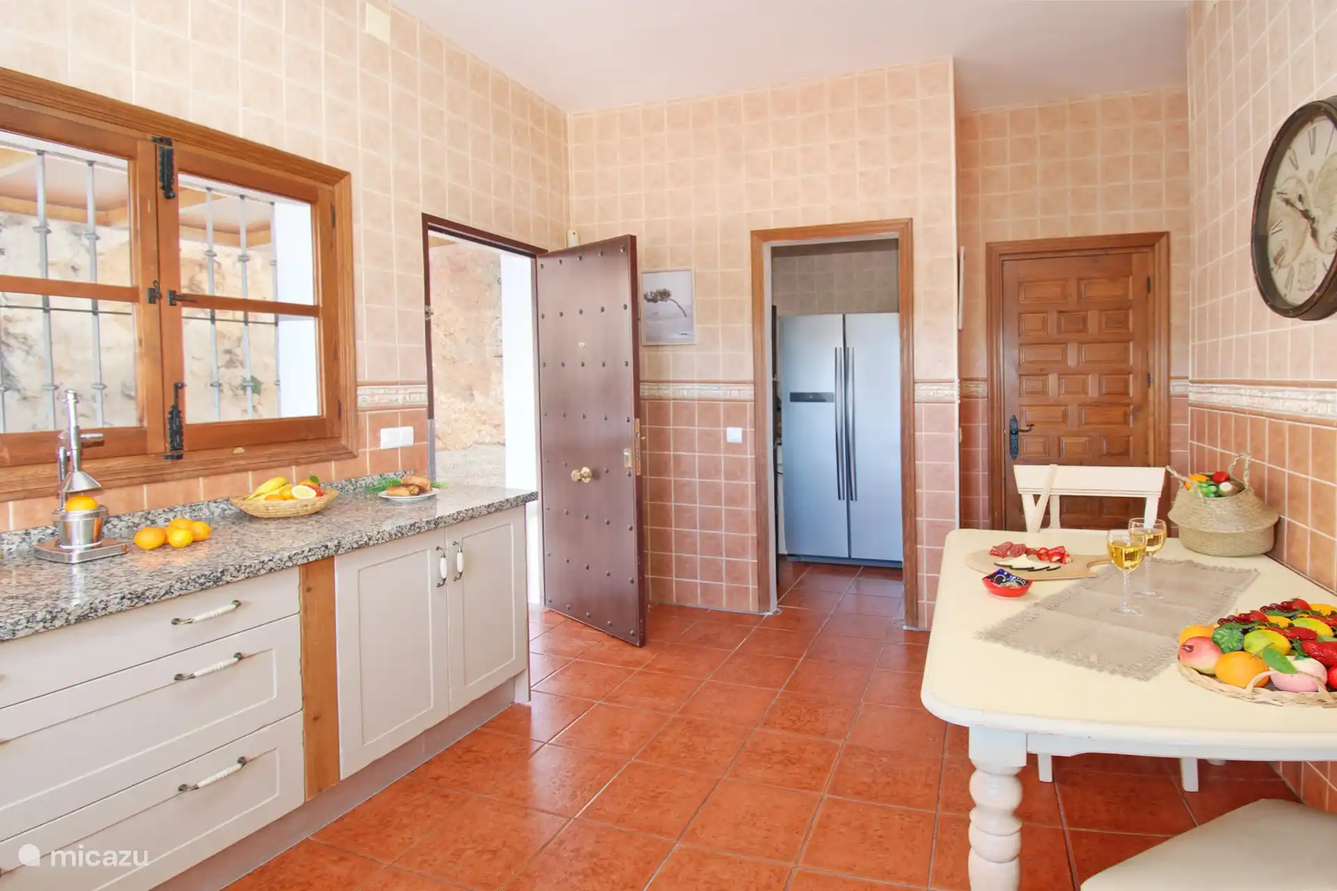 Große Küche mit amerikanischem Kühlschrank und Zugang zur Terrasse und zum Grillplatz