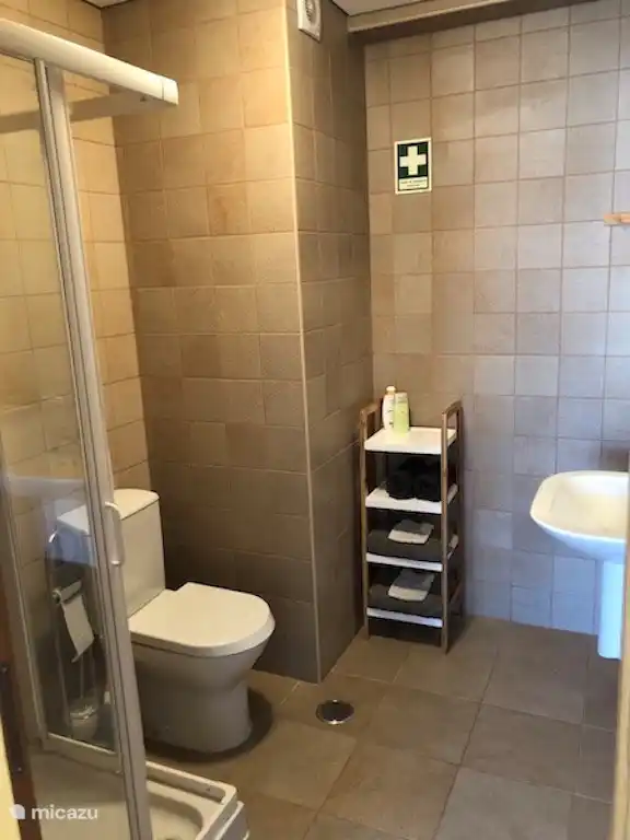 cuarto de baño, justo al lado del dormitorio, con ducha, inodoro y lavabo