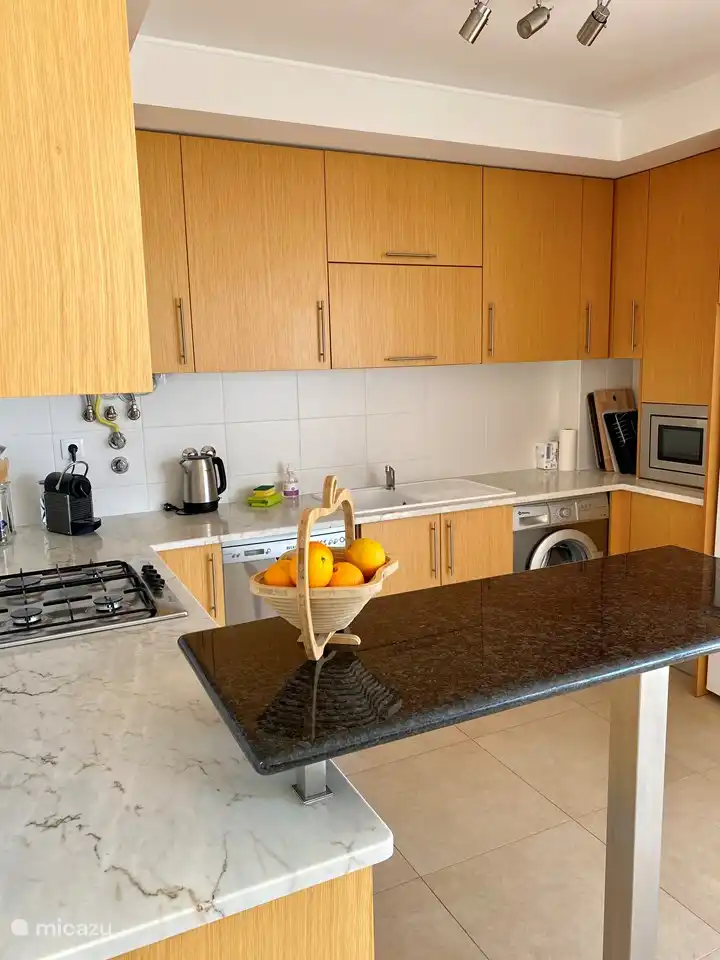 Cocina equipada con horno, microondas, lavadora, frigorífico-congelador, vitrocerámica de 4 fuegos y lavavajillas.