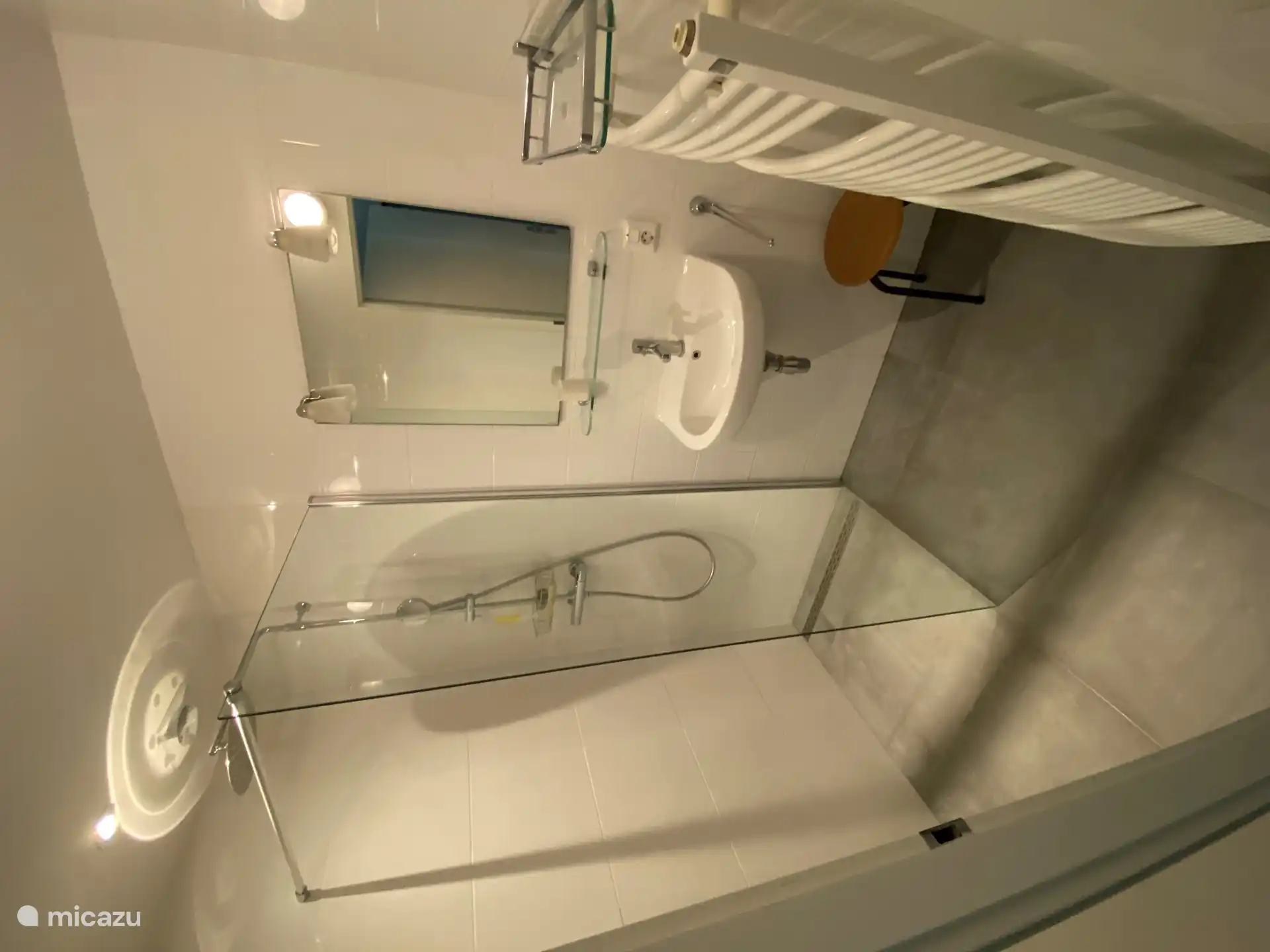 Badezimmer 2 mit Waschbecken, ebenerdiger Dusche und Heizkörper