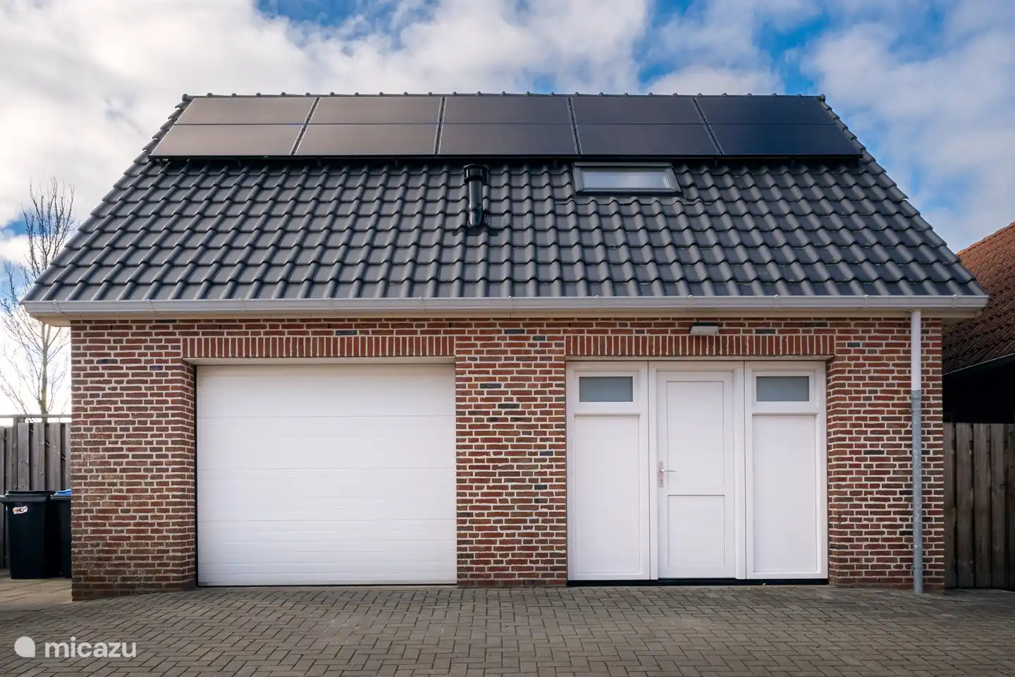 Entree van het huisje waar de auto voor de deur geparkeerd kan worden.