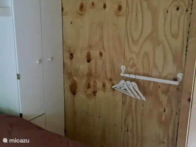 stacaravan huren in Nederland, Texel, De Cocksdorp – Sammie op Texel In de slaapkamer met het tweepersoons bed staat een grote kledingkast.