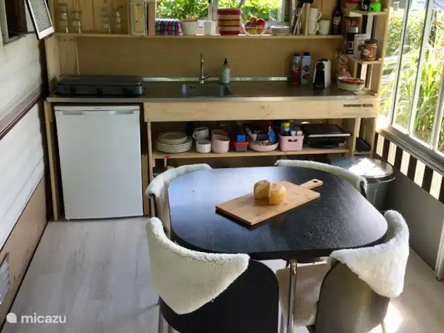 stacaravan huren in Nederland, Texel, De Cocksdorp – Sammie op Texel De ingerichte keuken met eettafel in het tenthuisje.