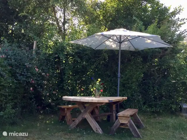 stacaravan huren in Nederland, Texel, De Cocksdorp – Sammie op Texel Heerlijk buiten eten, een spelletje spelen of lekker lezen aan de robuuste houten tafel met bankjes.
Leuk weetje: de tafel is gemaakt door dezelfde houtkunstenaar als de houten keuken in het tenthuisje.