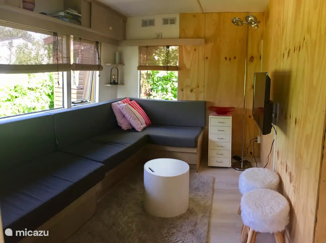 Ein schönes Fernsehzimmer oder Wohnzimmer mit einem schönen langen Sofa mit maßgefertigten Kissen.